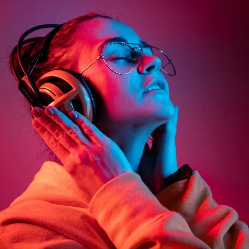 Mulher ouvindo música nos fones de ouvido olhando para cima com ar de satisfação